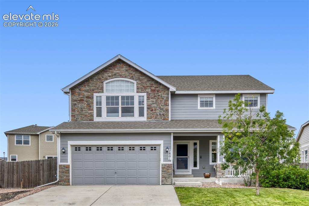 Caption: Two-story residence featuring a partial stone facade and light gray siding