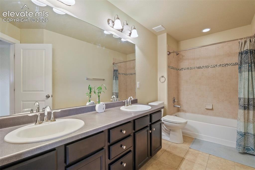 Image 22 of 33: Upper Level: Bathroom featuring a dual vanity with dark wood-finish cabinet