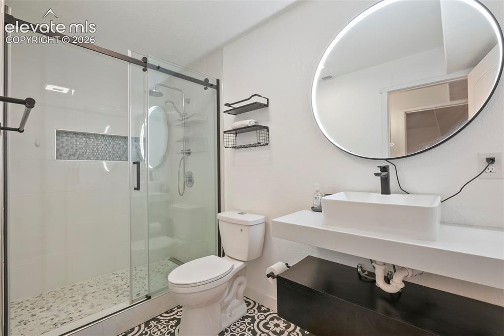 Image 27 of 33: Basement: Modern bathroom featuring a frameless glass shower enclosure with