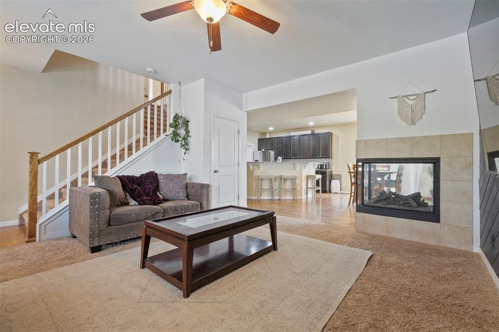Image 6 of 33: Main Level: Open-concept living space featuring a tiled fireplace with an i