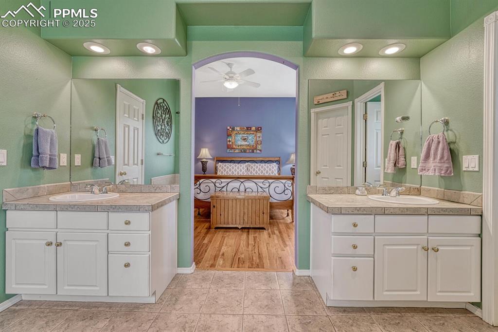 Image 28 of 50: primary bathroom with double vanities, jetted tub, separate shower, walk-in
