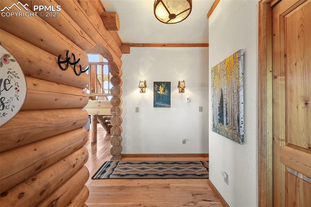 Image 10 of 50: Entrance foyer featuring hardwood / wood-style floors, log walls, and baseb