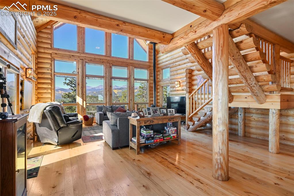 Image 18 of 50: Living area featuring hardwood / wood-style floors, high vaulted ceiling, s
