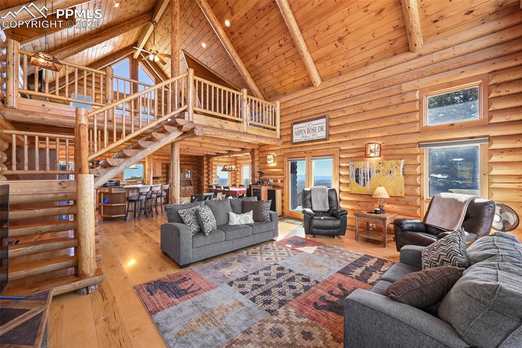 Image 21 of 50: Living room featuring wood-type flooring, wooden ceiling, stairway, and bea