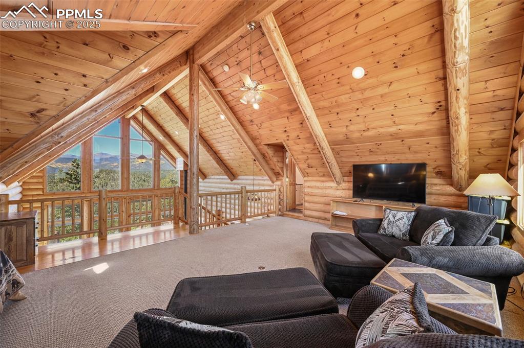Image 28 of 50: Living room with high vaulted ceiling, carpet, a ceiling fan, beam ceiling,