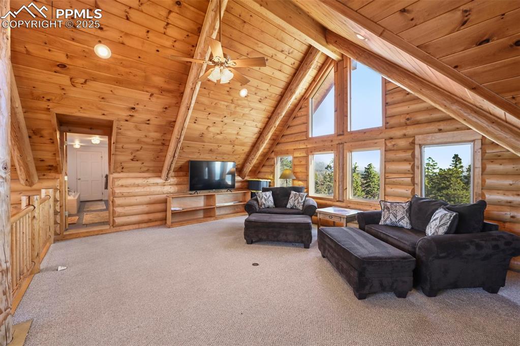 Image 29 of 50: Living area featuring high vaulted ceiling, wood ceiling, carpet floors, be