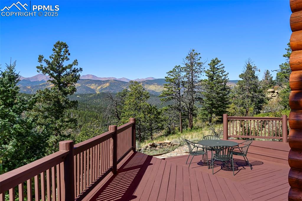 Image 34 of 50: Wooden deck featuring outdoor dining space and a mountain view