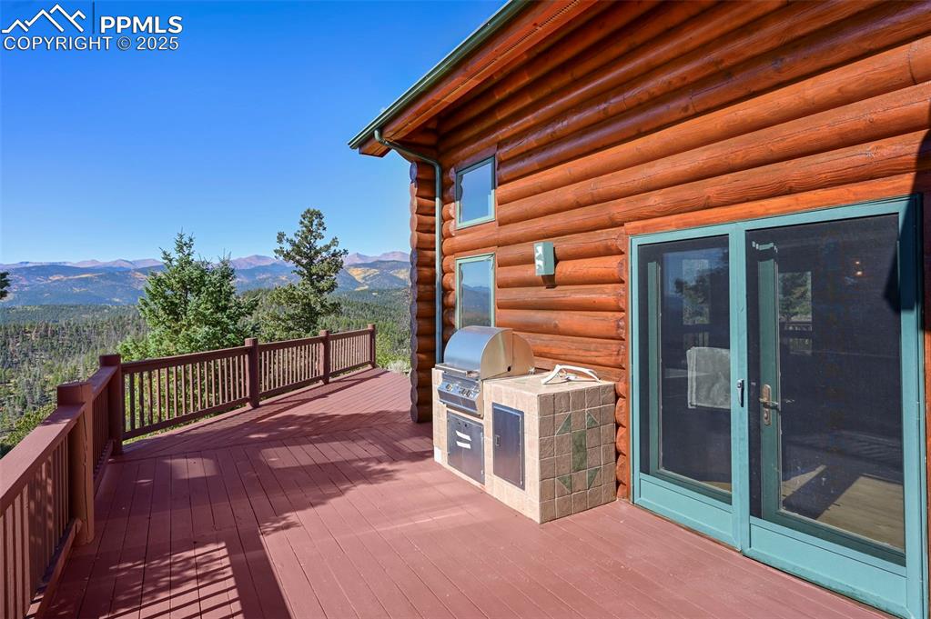 Image 35 of 50: Wooden deck featuring a mountain view and a grill