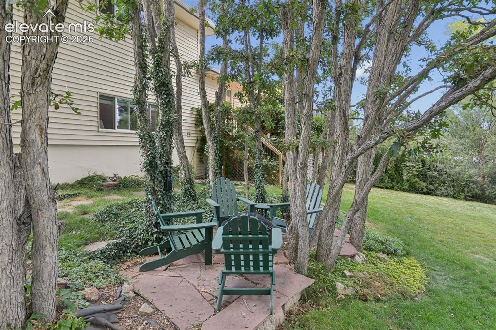 Image 47 of 48: Private space under the trees complete with firepit that conveys
