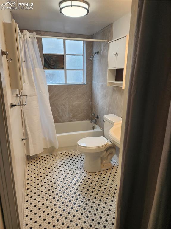 Image 18 of 22: Full bathroom featuring shower / tub combo, toilet, and tile patterned floo