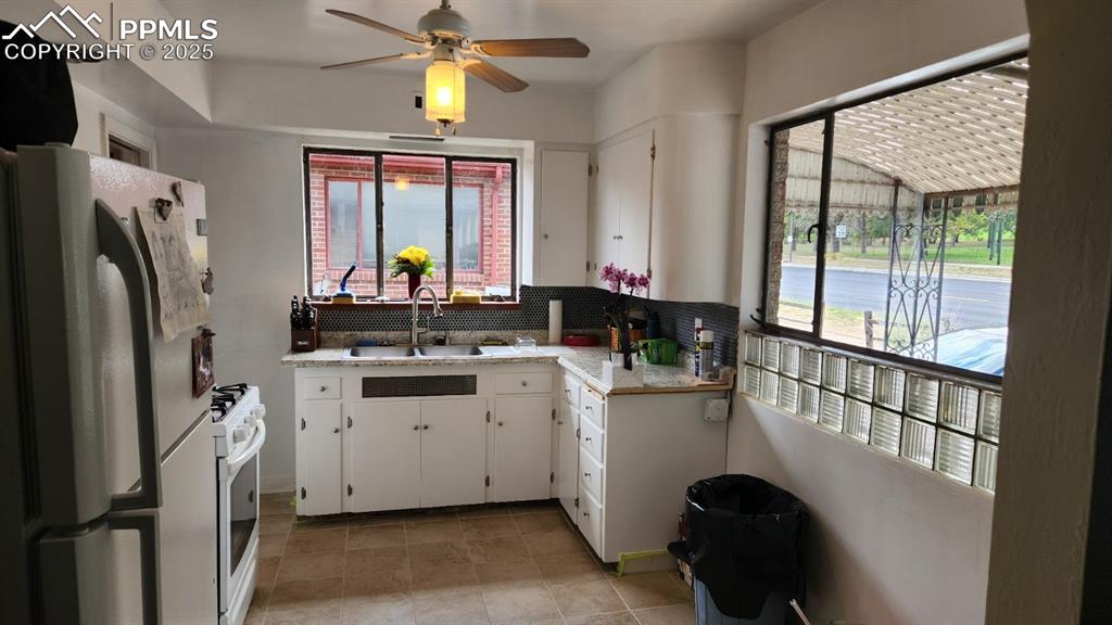 Image 2 of 22: Kitchen featuring a sink, freestanding refrigerator, white range with gas c