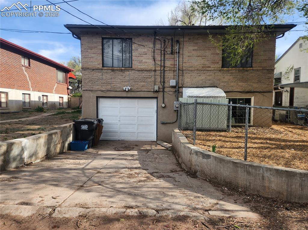 Image 21 of 22: View of front of property with an attached garage, concrete driveway, and b