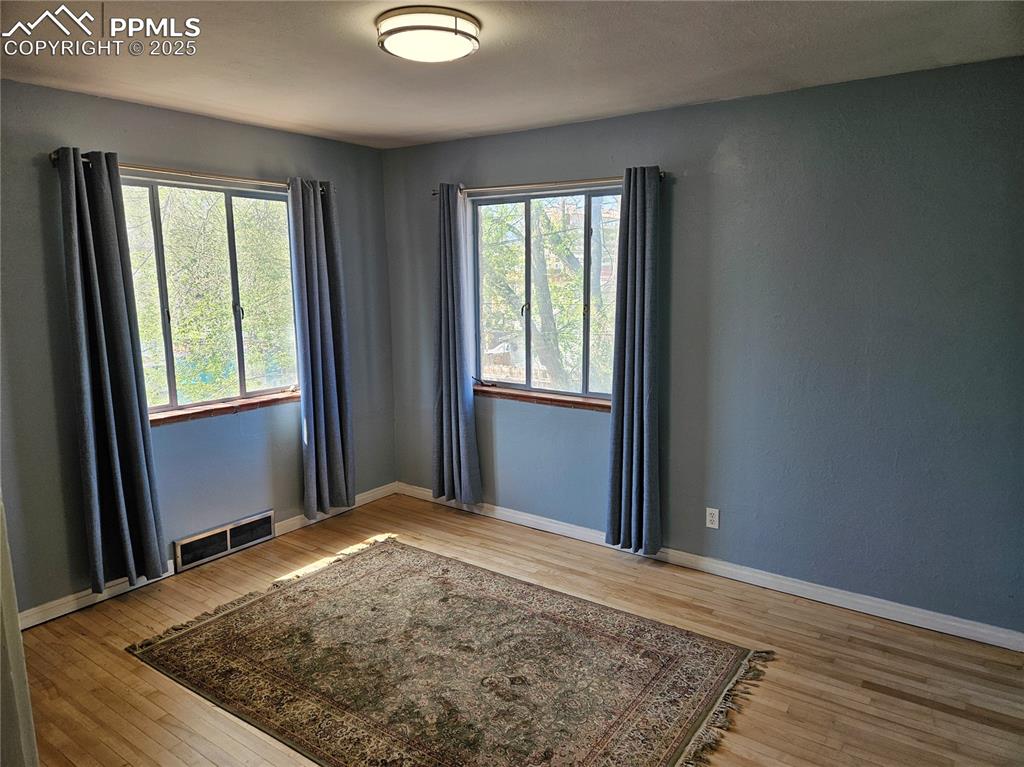 Image 5 of 22: Unfurnished room featuring hardwood / wood-style floors and baseboards
