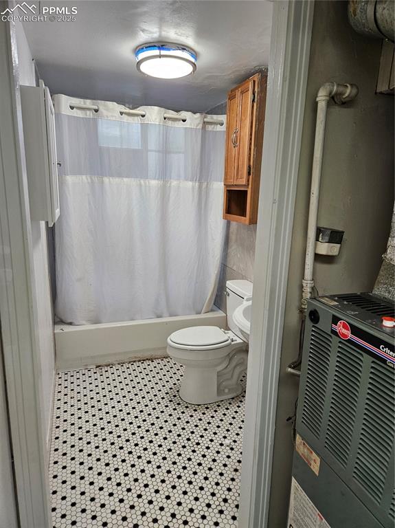 Image 7 of 22: Bathroom with toilet and shower / bath combo with shower curtain