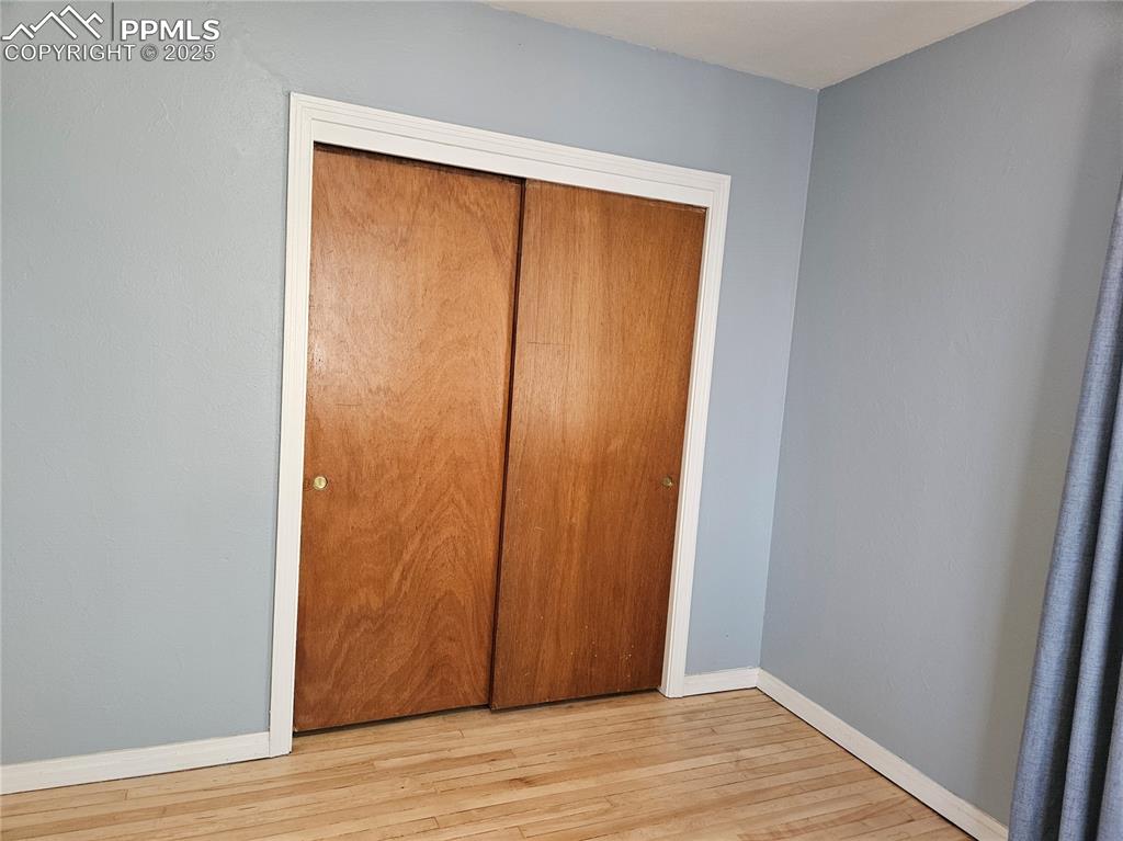 Image 8 of 22: Unfurnished bedroom featuring wood finished floors, baseboards, and a close