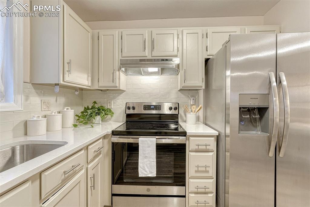 Image 5 of 30: Stainless steel appliances and timeless tile backsplash