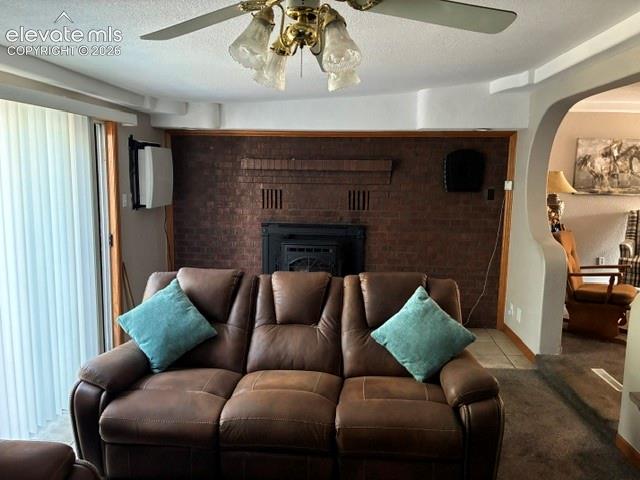 Image 4 of 16: Brick-clad fireplace with mantel, ceiling fan with integrated lighting, woo