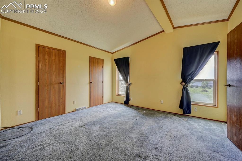Image 14 of 48: Unfurnished bedroom with a textured ceiling, ornamental molding, and carpet