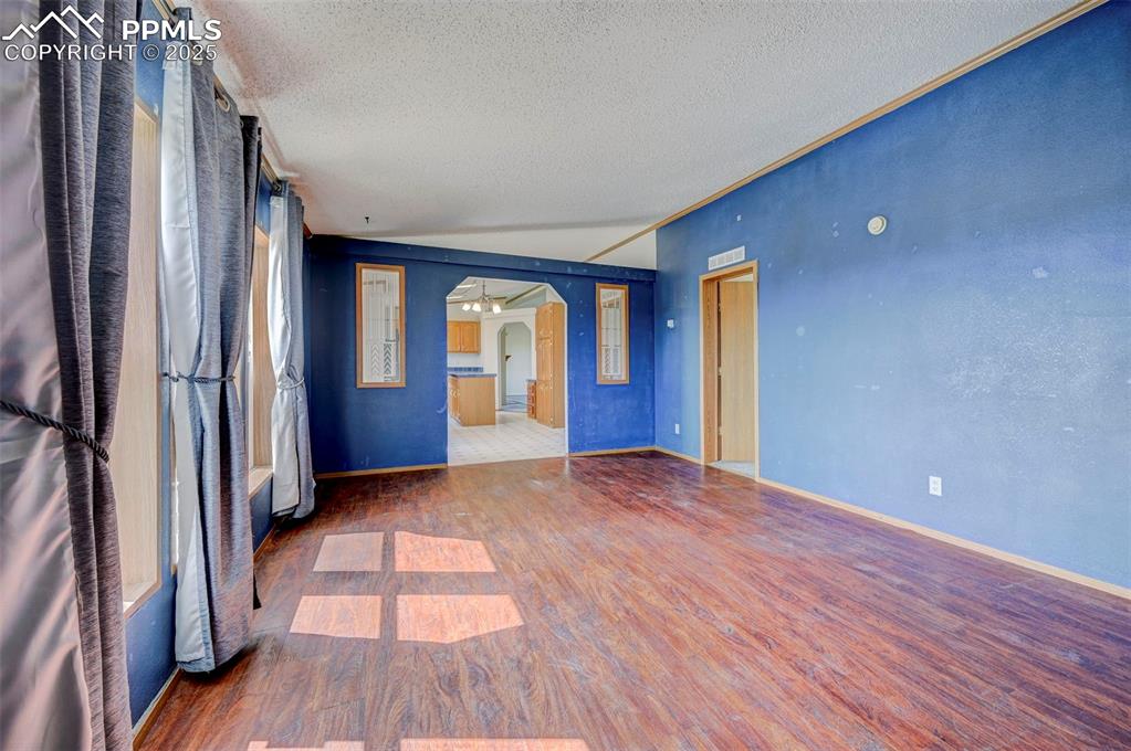 Image 27 of 48: Unfurnished room featuring wood finished floors, a textured ceiling, a ceil