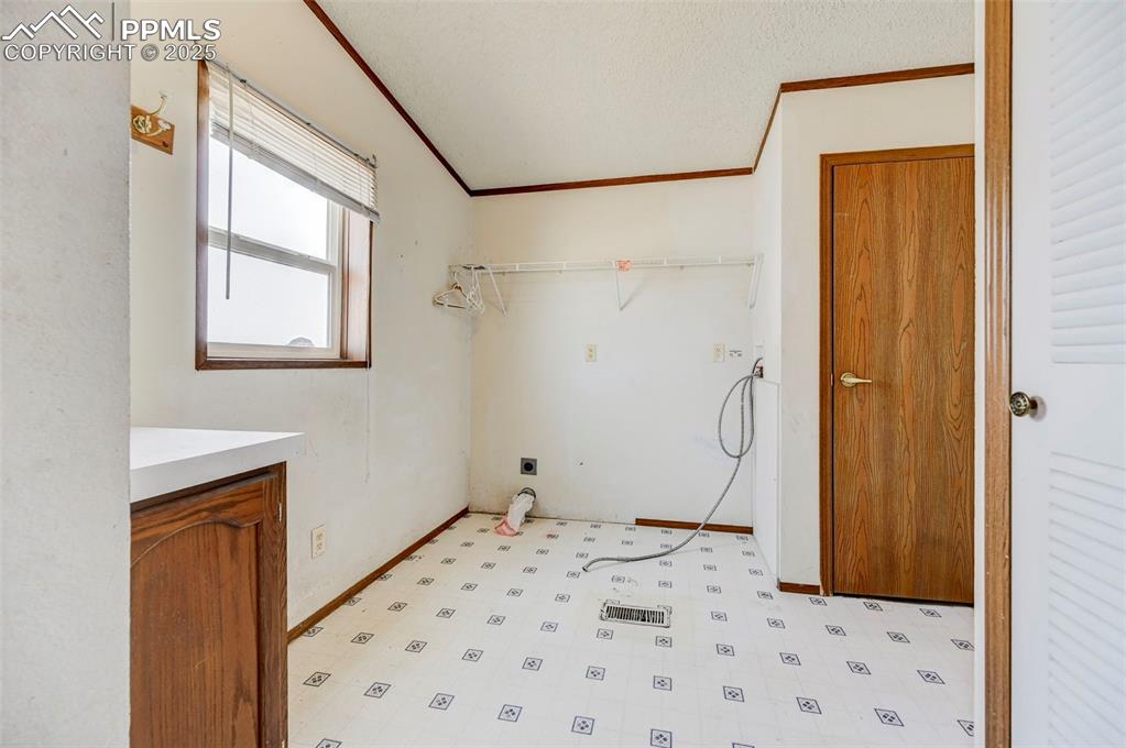 Image 40 of 48: Washroom featuring crown molding, baseboards, light flooring, and hookup fo