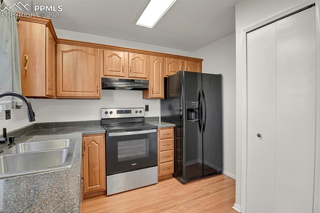 Image 12 of 31: Kitchen featuring stainless steel electric stove, black refrigerator with i