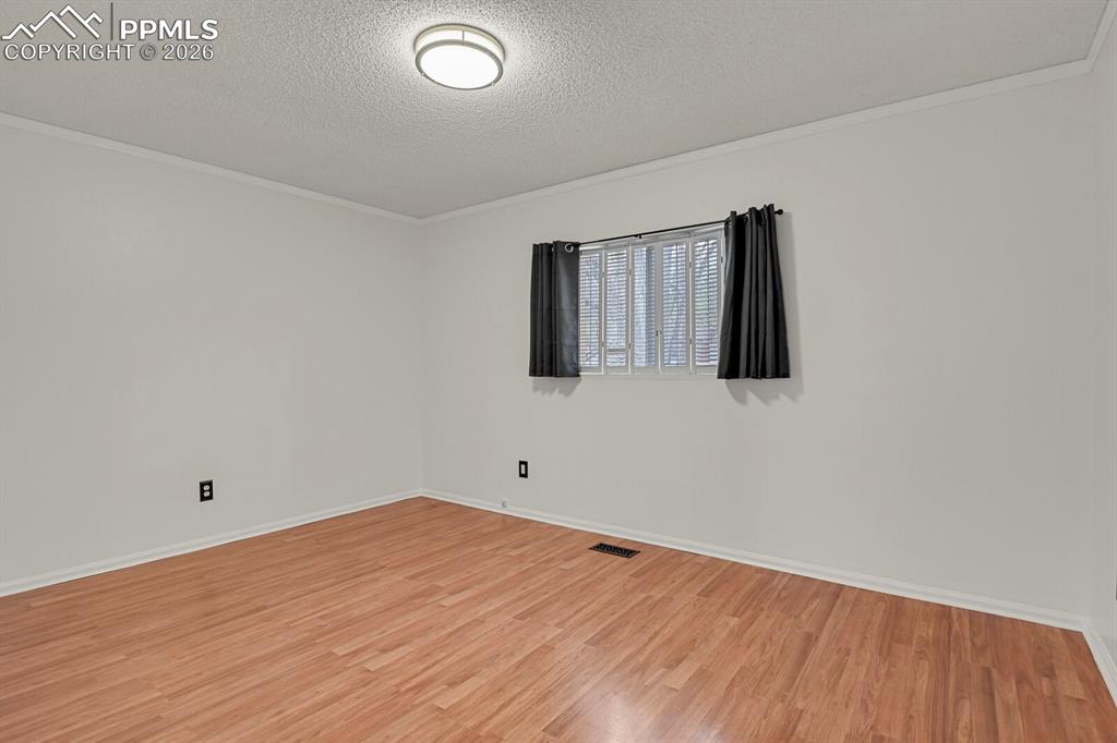 Image 13 of 31: Empty room featuring light wood finished floors, a textured ceiling, and or