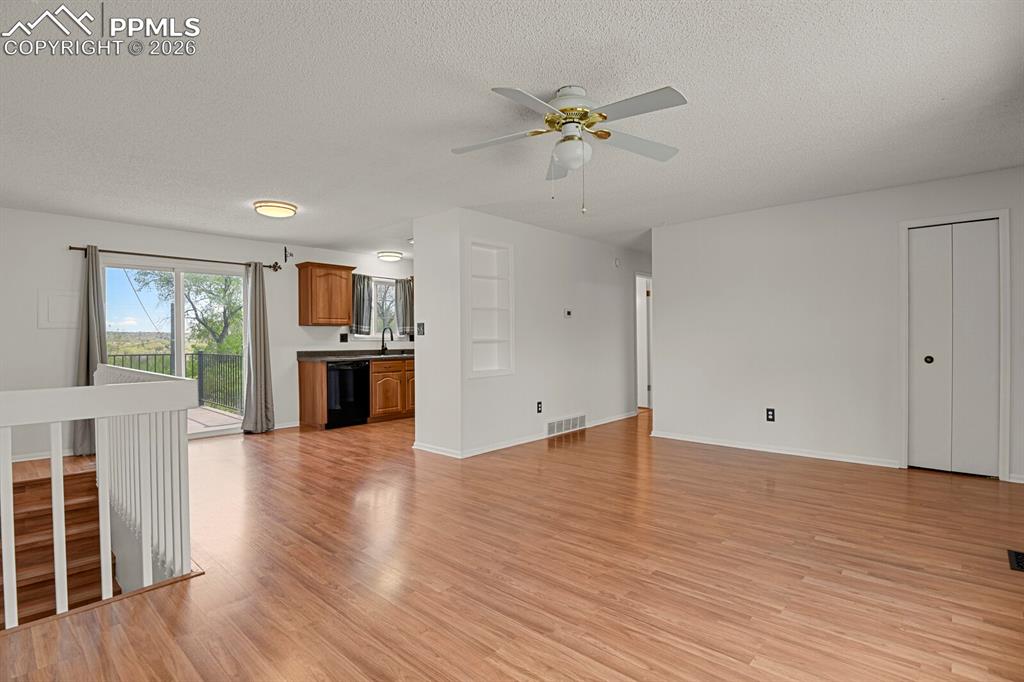 Image 4 of 31: Unfurnished living room featuring a textured ceiling, light wood-type floor