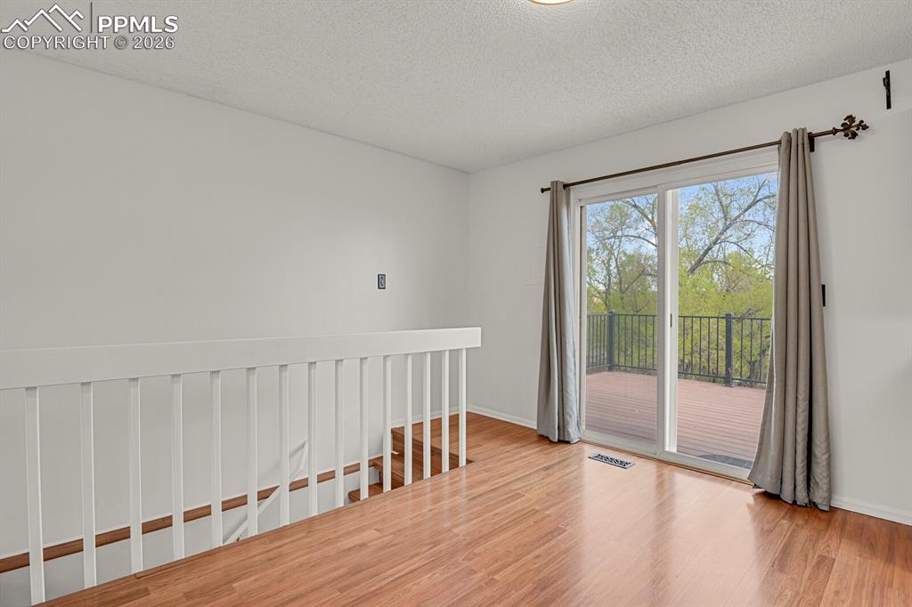 Image 7 of 31: Unfurnished room with light wood-type flooring and a textured ceiling