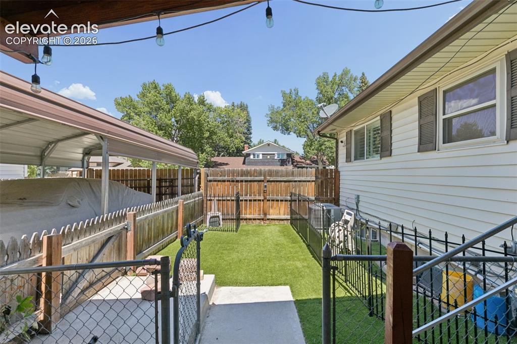Image 37 of 48: dog area or more space leading to the carport