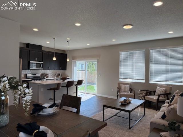 Image 2 of 6: Living room featuring a textured ceiling, wood finished floors, and recesse