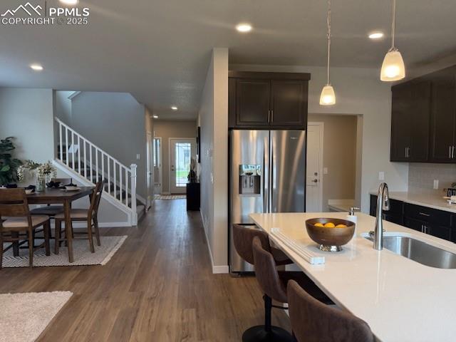 Image 4 of 6: Kitchen featuring stainless steel refrigerator with ice dispenser, dark woo