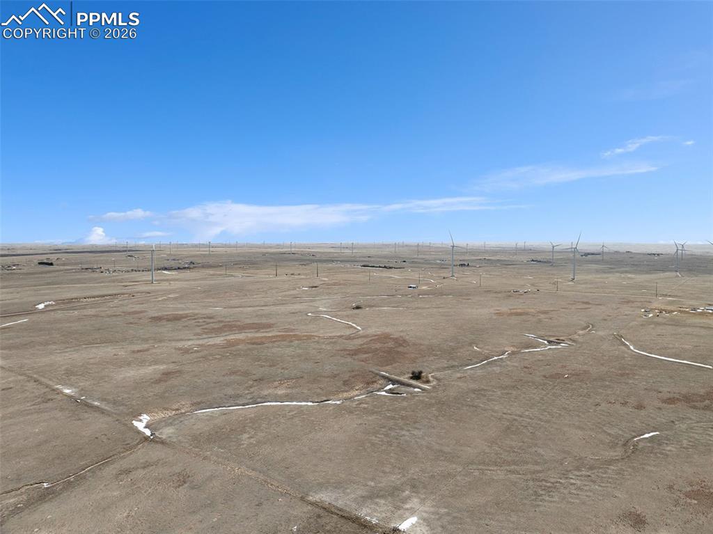 Caption: Ground-level view of the property showing open terrain and natural vegetation.