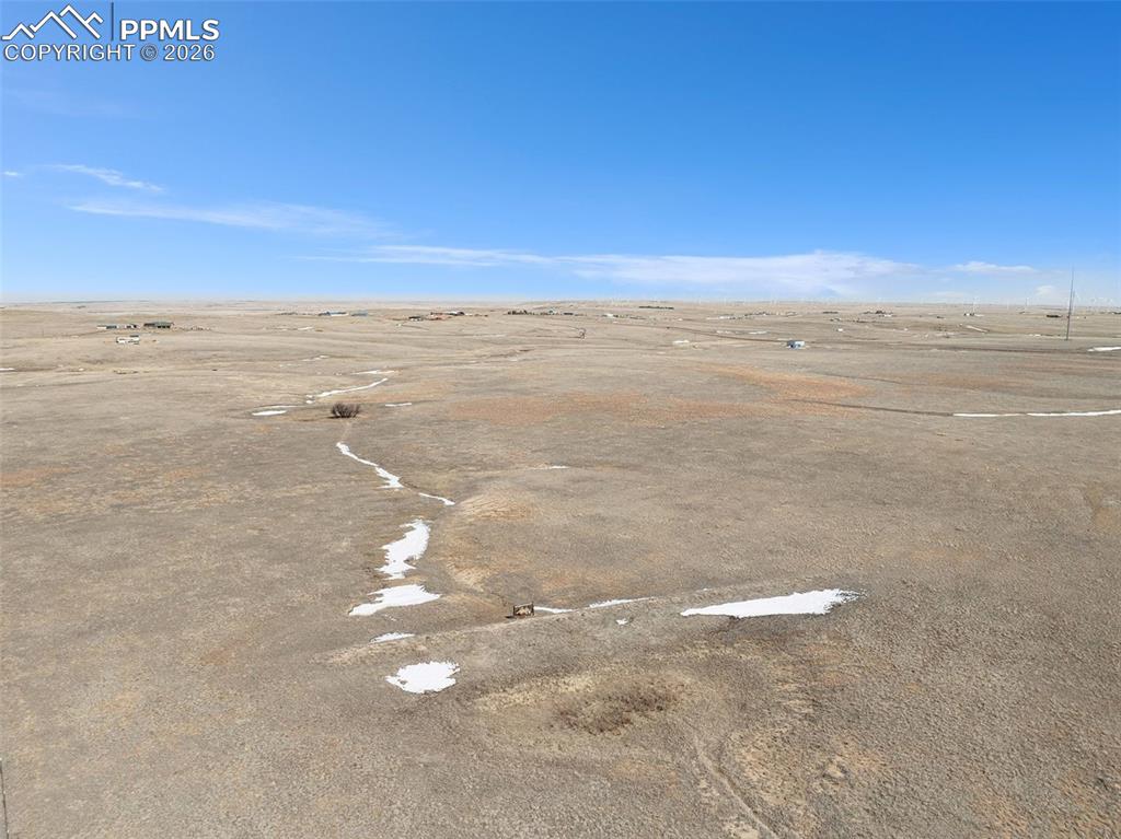 Image 2 of 17: Ground-level view of the property looking across the open landscape.