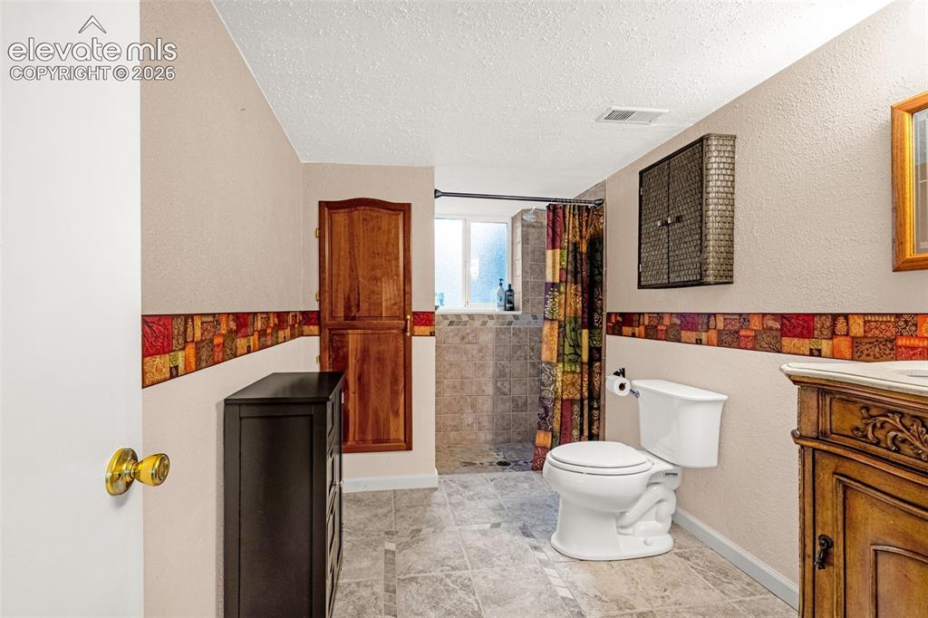Image 14 of 32: Lower level bathroom is spacious, has tile flooring, large linen closet and