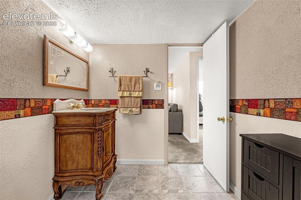 Image 15 of 32: Another view of the lower bathroom with custom tile inlay design and steps 