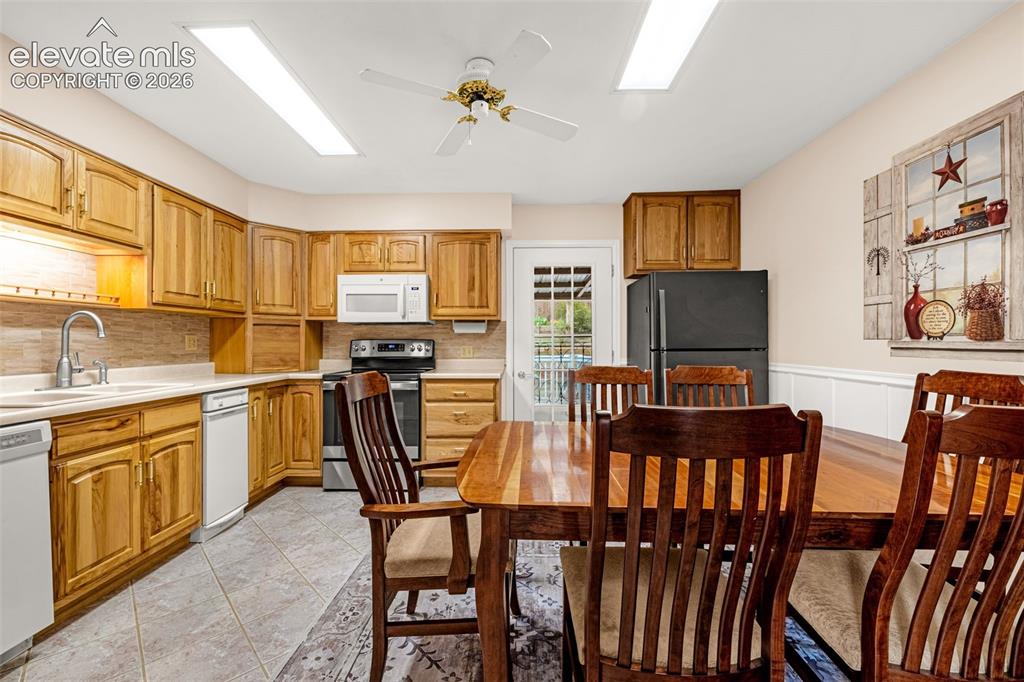 Image 2 of 32: Heart of the home the walk-out kitchen; tile flooring, wall of hickory cabi