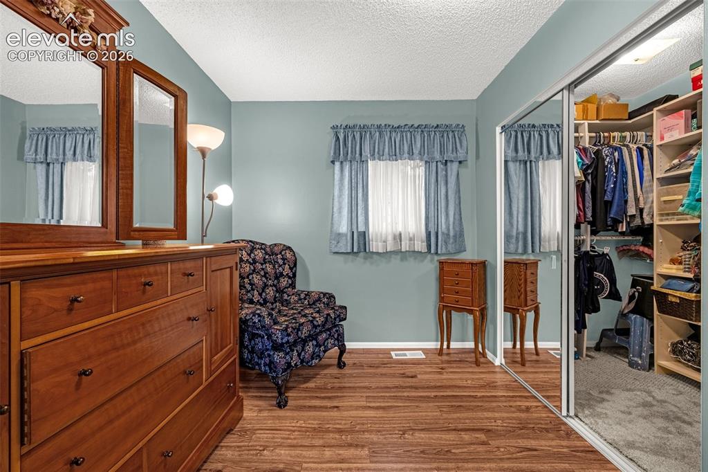 Image 9 of 32: Primary bedroom sitting/reading area with a view of the walk-in closet with