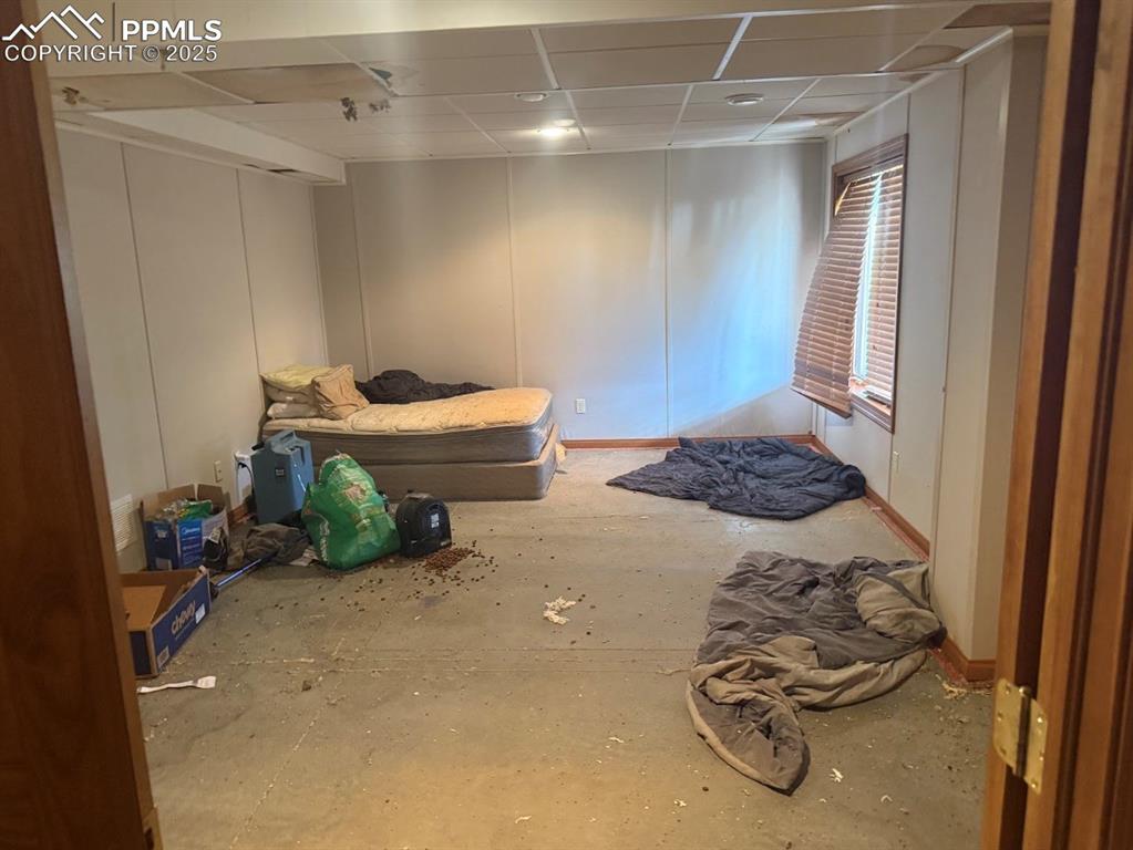 Image 26 of 36: Bedroom with a paneled ceiling and a decorative wall