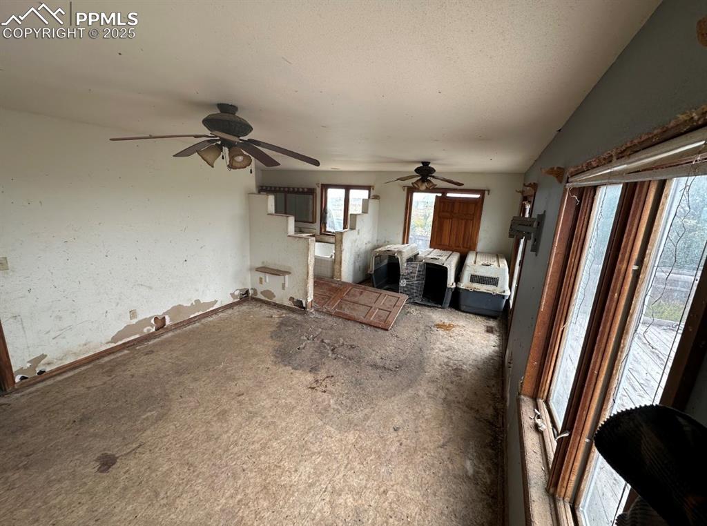 Image 27 of 36: Living area with a textured ceiling, vaulted ceiling, a ceiling fan, and he