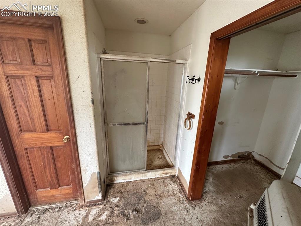 Image 30 of 36: Bathroom with a shower stall and a spacious closet