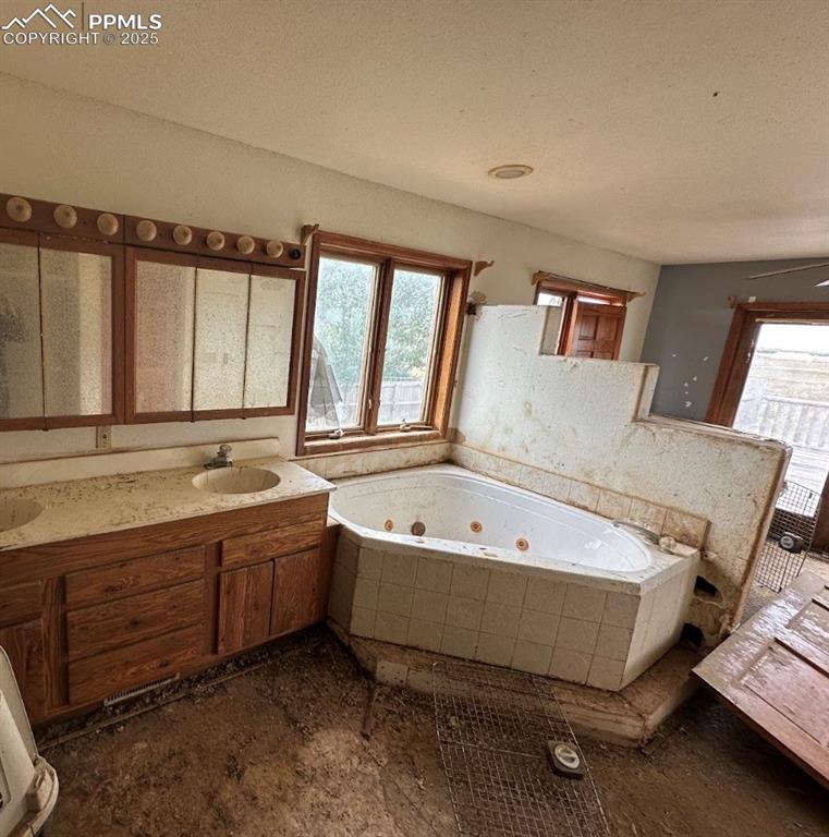 Image 32 of 36: Bathroom with a tub with jets and double vanity