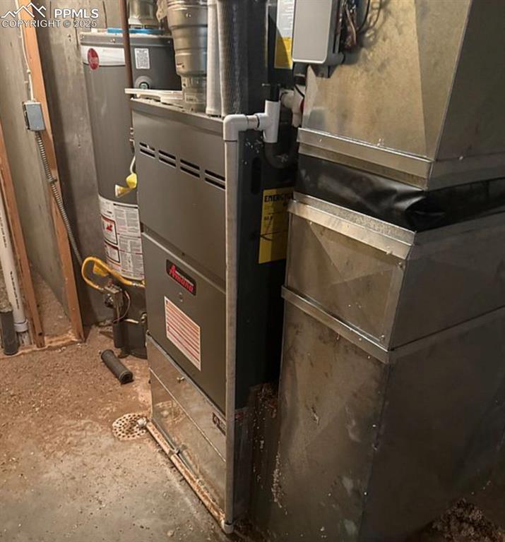 Image 35 of 36: Utility room featuring heating unit and gas water heater