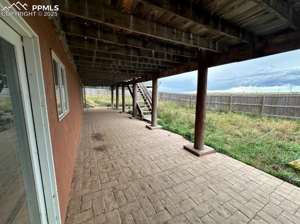 Image 7 of 36: Fenced backyard featuring a patio and stairway