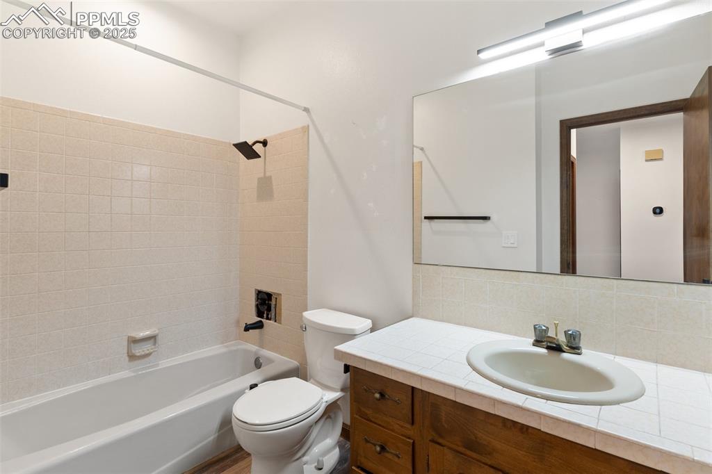 Image 14 of 23: Bathroom featuring vanity, toilet, washtub / shower combination, and tastef