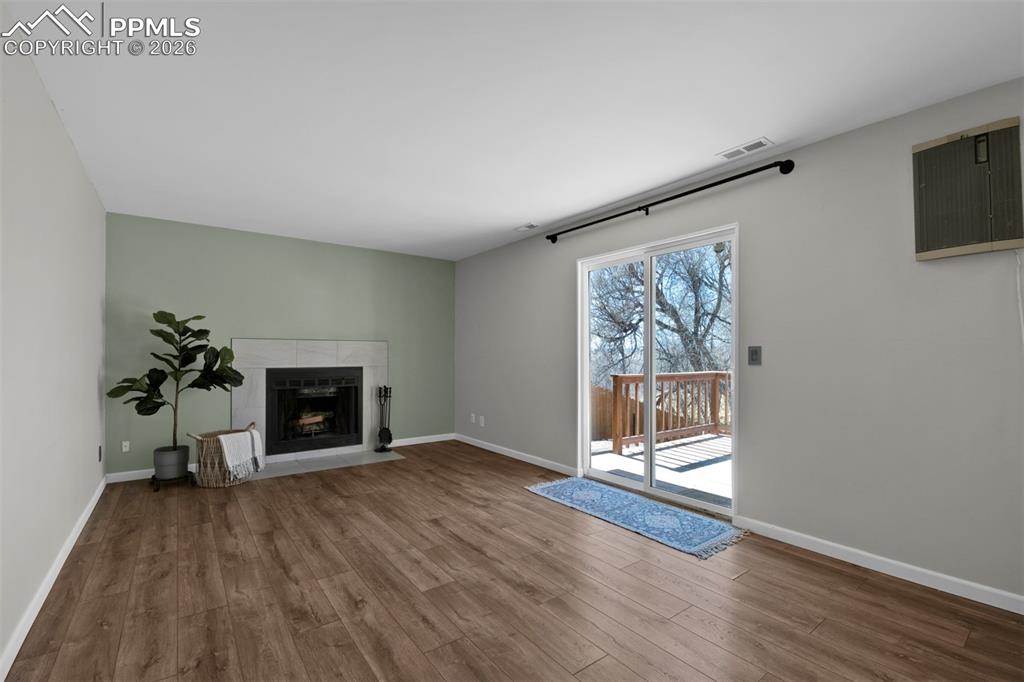 Image 30 of 42: Large family room with fireplace and walk-out to deck and yard. 