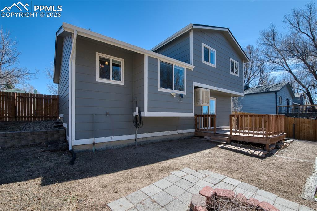 Image 34 of 42: Back of the home showing deck, patio area and firepit. 