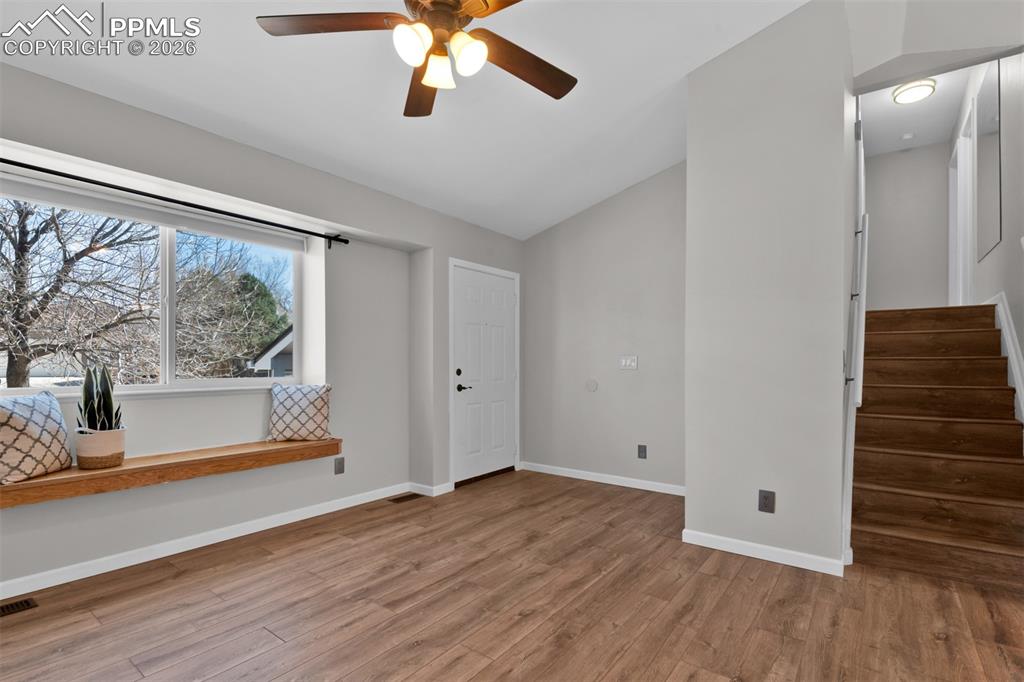 Image 9 of 42: Living room showing entry and stairs to upper level.