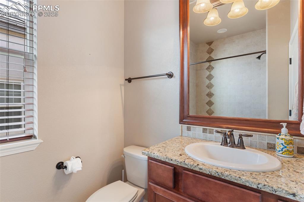 Image 12 of 27: Bathroom featuring vanity, decorative backsplash, and plenty of natural lig