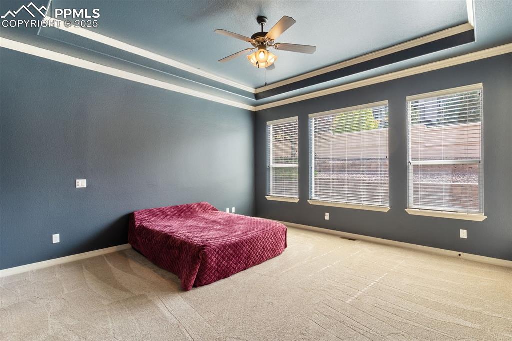 Image 14 of 27: Bedroom featuring a raised ceiling, carpet flooring, ornamental molding, an