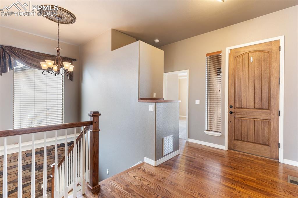 Image 2 of 27: Foyer with wood finished floors and a chandelier